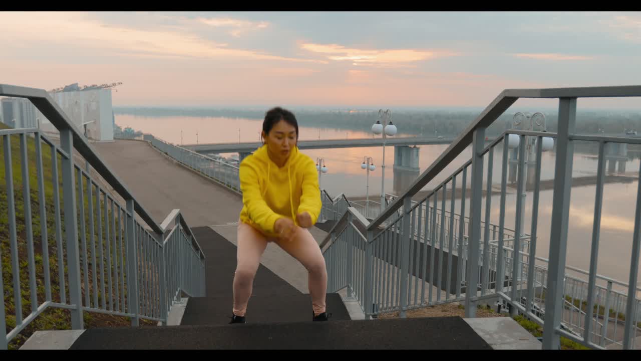 Woman doing squats on stairs outdoors
