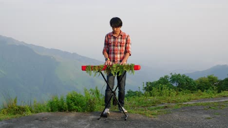 Una-Filmación-Estacionaria-De-Un-Hombre,-Tocando-Su-Teclado-Musical-Electrónico-Con-Una-Vista-A-La-Montaña-En-El-Fondo