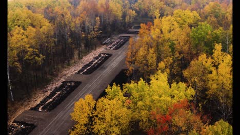 Aerial-shot-of-yellow-and-red-forest-along-a-misty-river