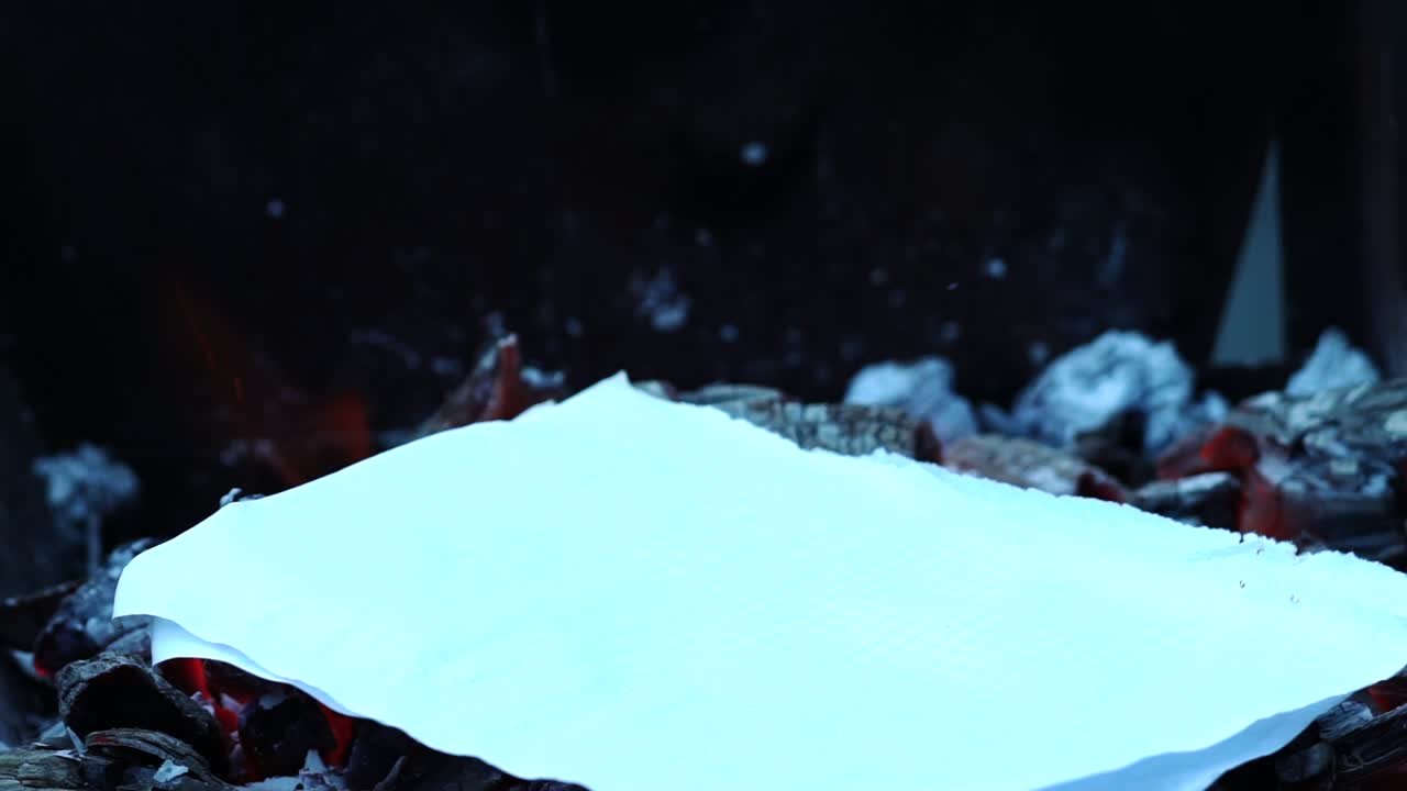 Paper burning in the bonfire flame. Camp fire in the night. Slow motion