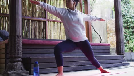 african american woman performing stretching exercise at vacation home