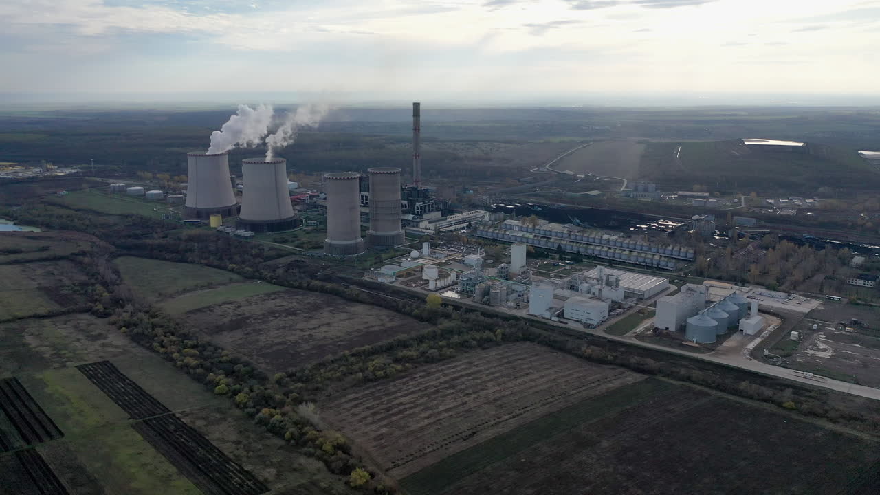 Aerial clip of a coal powerplant with smoke going up in the air. Dolly in shot