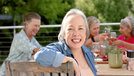 senior biracial woman enjoys a hearty laugh at an outdoor gathering