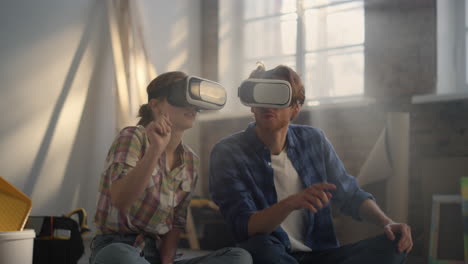 Focused-family-making-layout-in-vr-glasses.-Couple-using-headsets-indoors.