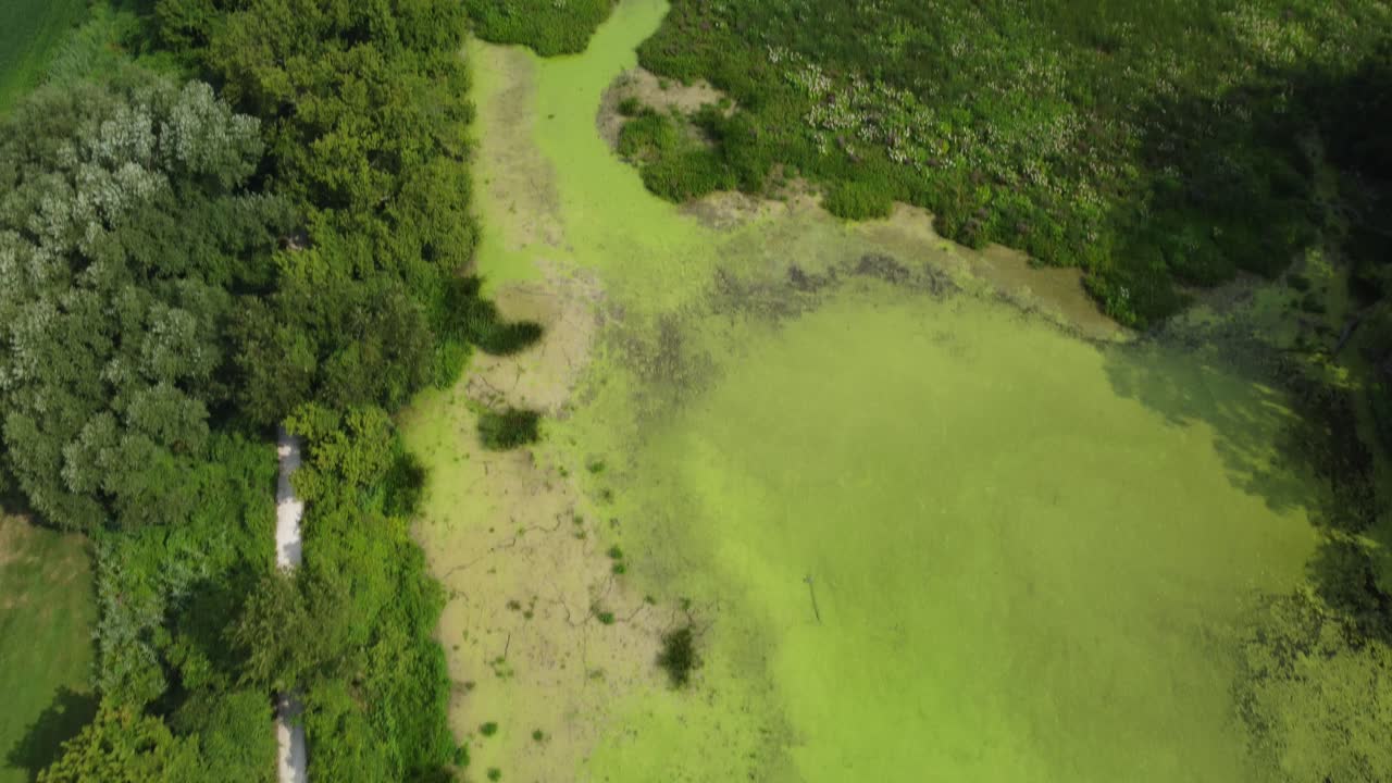 old rail tracks next to swamp and agricultural land drone view