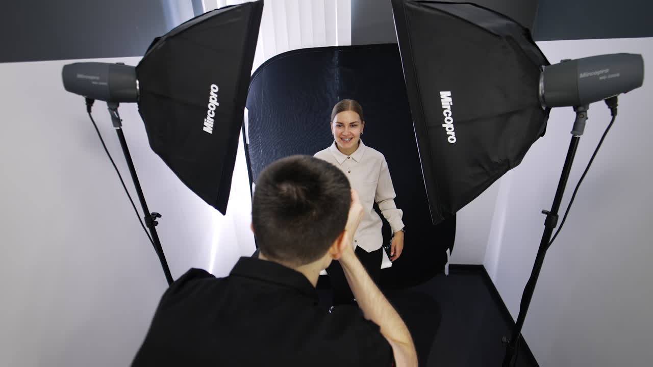 Male dentist in black uniform taking picture of a smiling female patient. Doctor's portfolio replenishment.