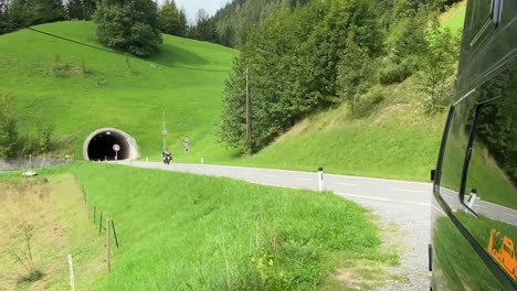 entrance to a tunnel in the alps showing motorbikes and holiday traffic entering and leaving