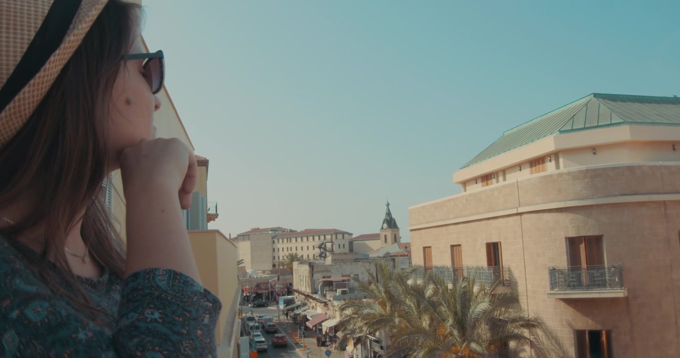 Donna con cappello che guarda lungo la strada