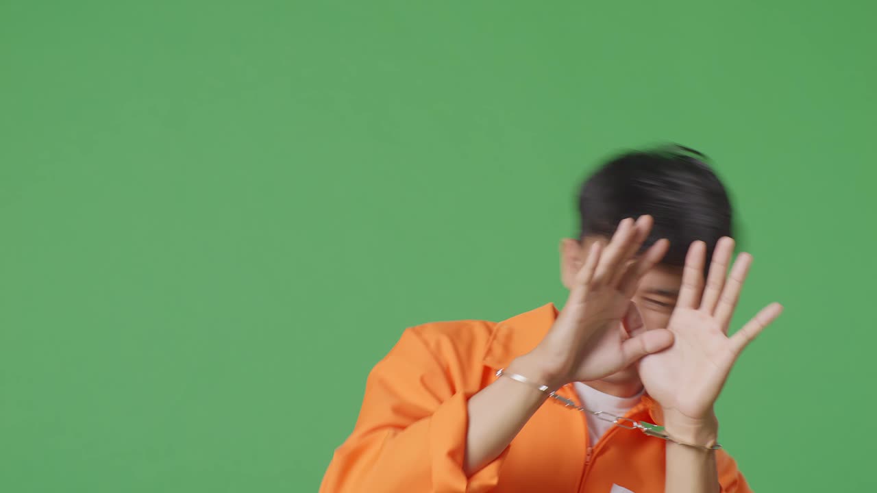 오렌지색 스웨터와 수갑을 입은 남자