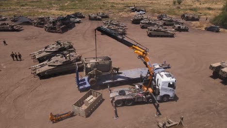 civilian crane lifting heavy idf equipment off a truck ready for gaza deployment