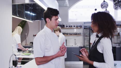 african american female restaurant manager in the kitchen,giving instructions