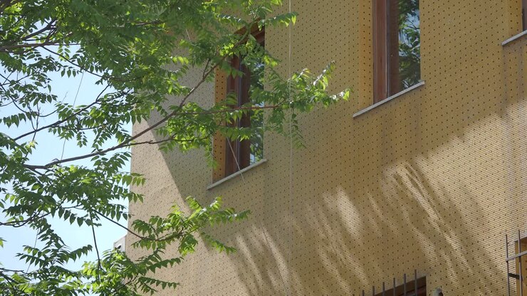 Edificio con facciata gialla e alberi