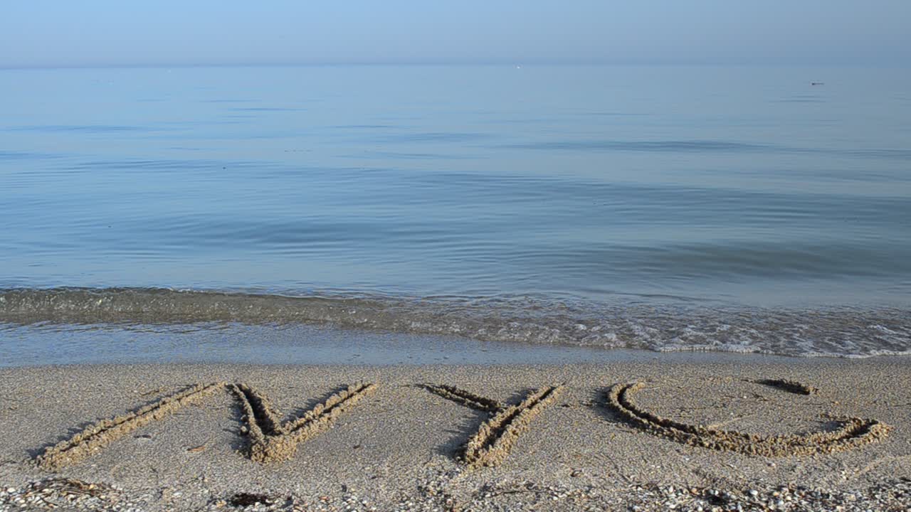 The inscription NYC on sand. Inscription on sand, the beach
