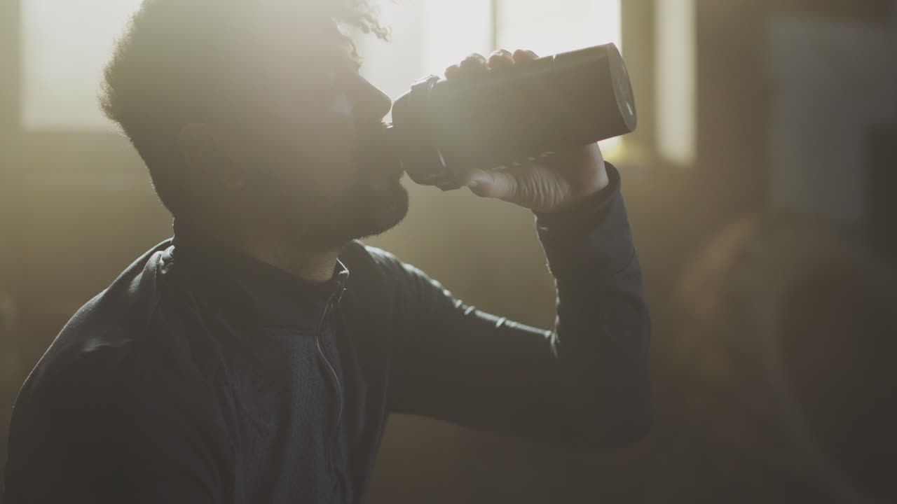 Uomo che beve una bevanda sportiva dopo l'allenamento