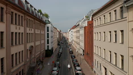 Forwards-tracking-shot-of-cyclists-riding-through-Linienstrasse-cycle-route-street.-Promoting-green-transport-in-city.-Berlin,-Germany.