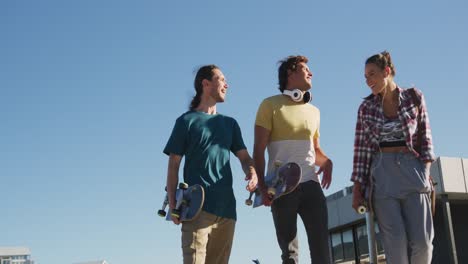 happy caucasian woman and two male friends, walking, talking and spending time together on sunny day