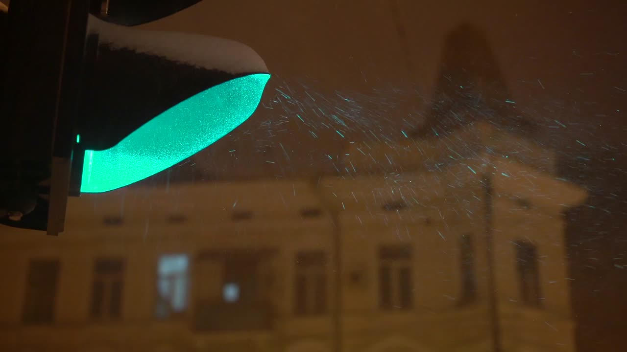 밤에 눈 속의 초록색 신호등