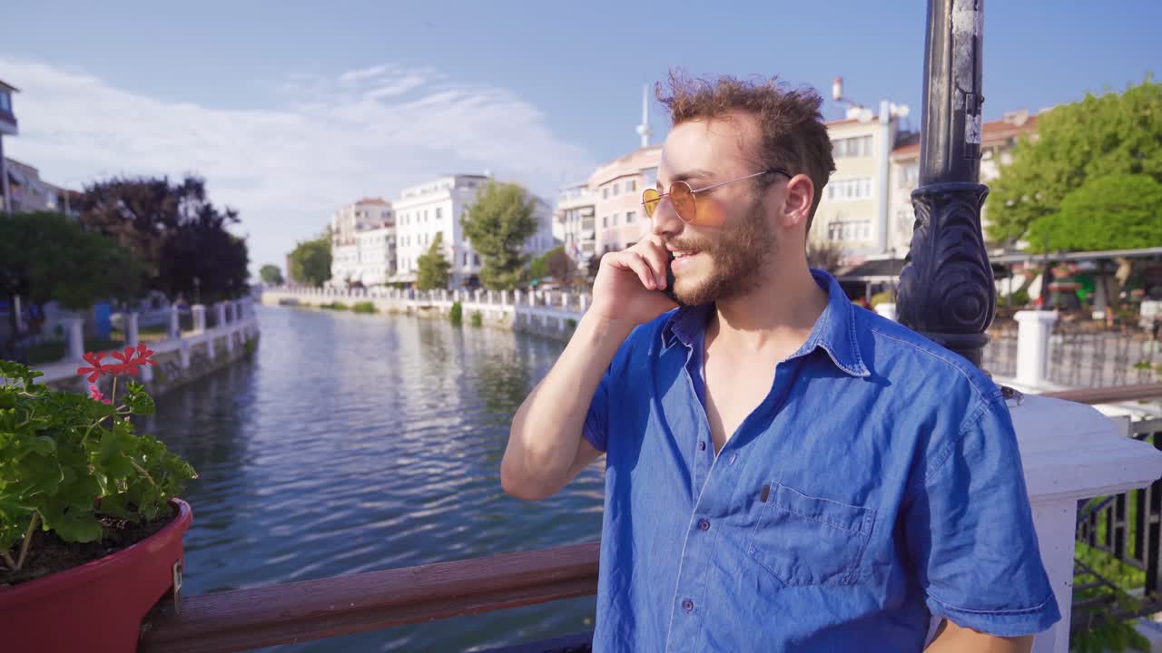 현대 도시에서 전화로 이야기하는 젊은 남자.