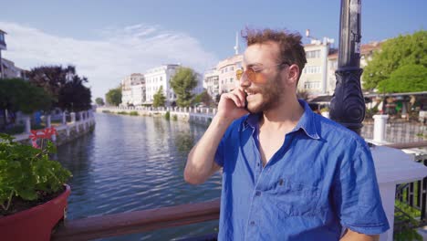 young man talking by phone in modern city.