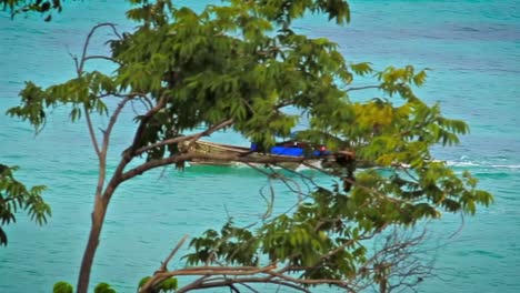 a fisherman on a tail boat sailing on the crystal clear blue water
