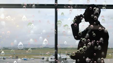 Digital-composite-video-of-American-dollar-bills-moving-against-man-drinking-coffee-at-airport-in-ba