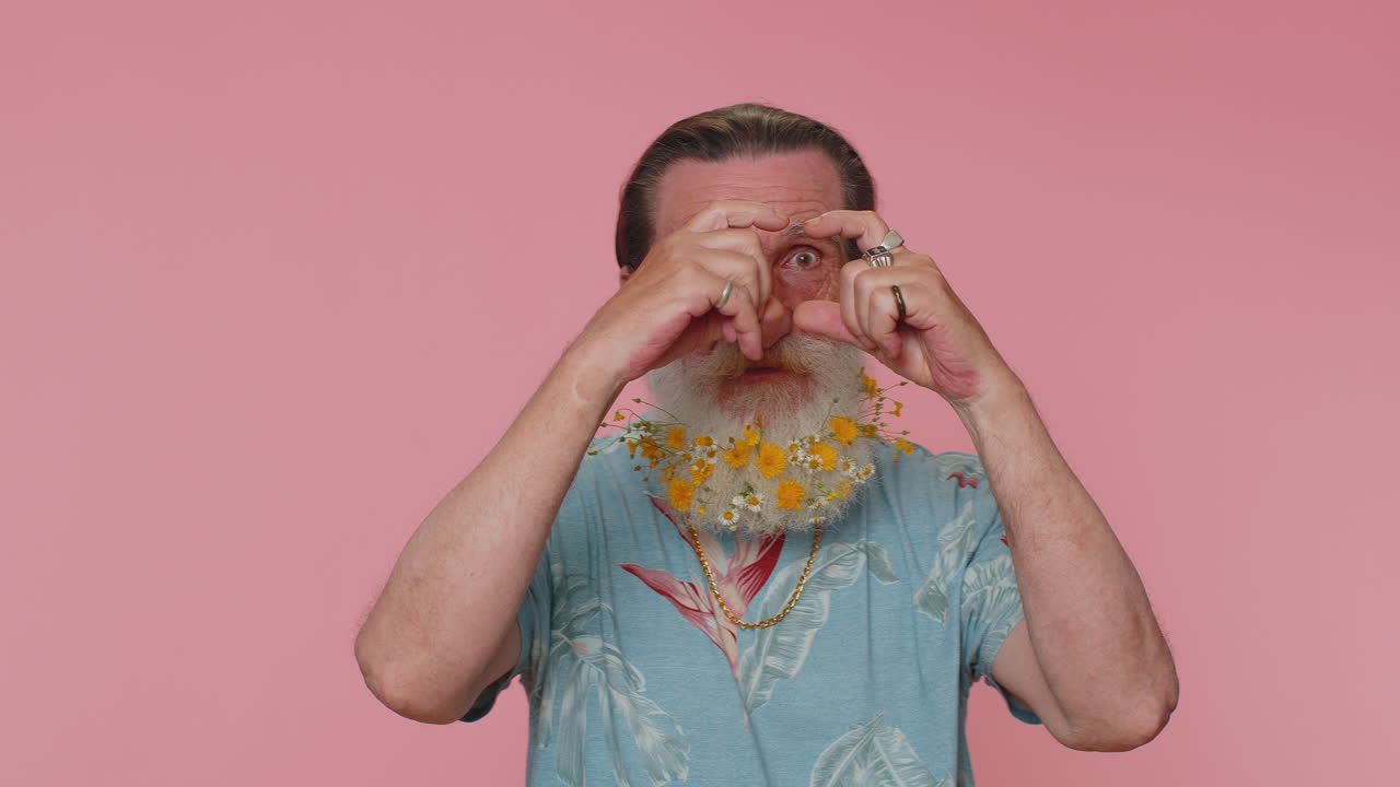 anciano fotógrafo gestando el marco de la imagen con las manos imitando el zoom, recortando una buena imagen