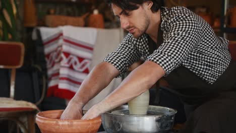 el ceramista utiliza la rueda del alfarero y crea un producto de arcilla hecho a mano