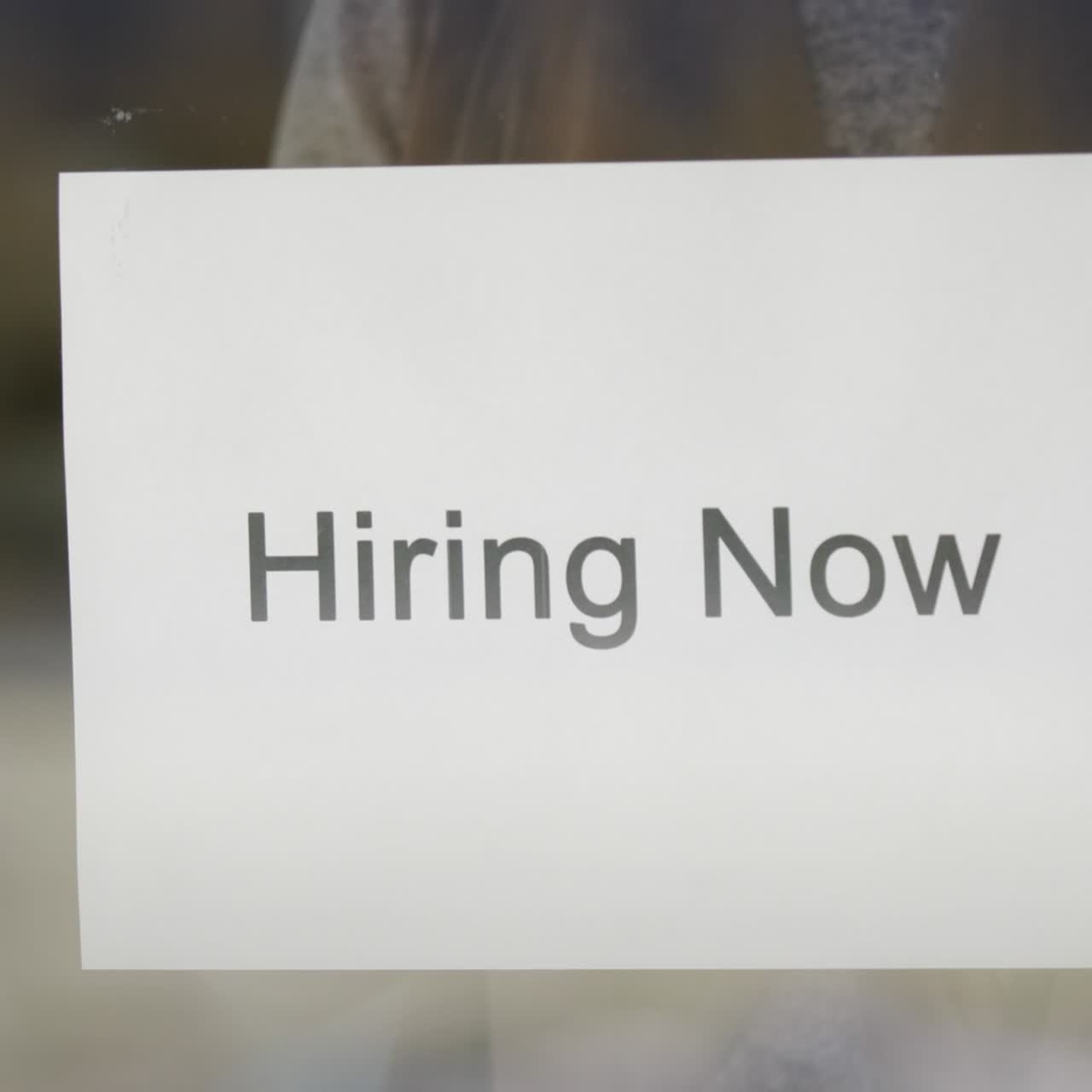 Employee Hangs On The Door Ad Hiring Now