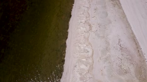 Drone-Flying-over-desert-next-to-sea,-ocean,-lake---salton-sea,-california