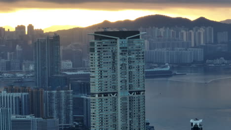 Drone-parallax-shot-of-the-high-rise-K11-building-at-sunrise-with-Kai-Tak-Cruise-Terminal-in-background