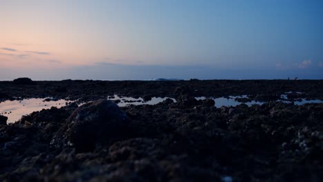 Low-Angle-Aufnahme-Des-Suluban-Creek-Auf-Bali-Während-Der-Ebbe-Bei-Sonnenuntergang,-Wobei-Sich-Der-Himmel-Im-Wasser-Spiegelt