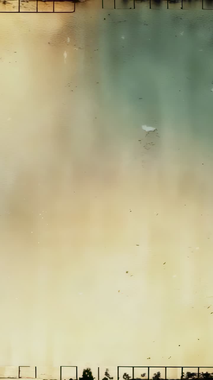 Vertical video: Displaying golden-beige gradient on screen, streaks and specks creating film effect