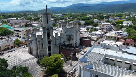 aerial orbit shot of historic cathedral in la vega city with traffic on main street