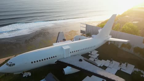 avión de pasajeros ahora villa de gama alta estacionada en el acantilado del océano de bali al atardecer