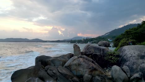 Aerial-footage-of-Grandfather-and-Grandmother-Rock-in-Koh-Samui-at-sunset,-showcasing-waves-crashing-against-the-iconic-rocks