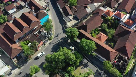 Antena-De-Arriba-Hacia-Abajo-De-Coches-Y-Motos-Conduciendo-En-Un-Barrio-Residencial-En-Bali,-Indonesia