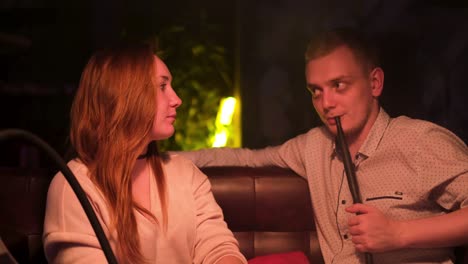 couple enjoying hookah in a cafe at night