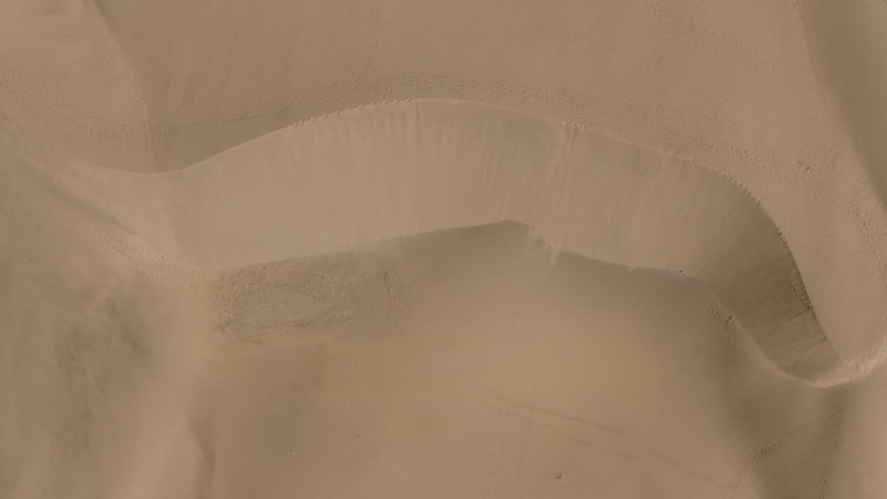 바람 부는 모래가 있는 사막에 있는 모래 언덕의 드론 탑 샷