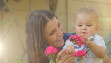 animation of glowing spots over happy caucasian mother with daughter holding flowers