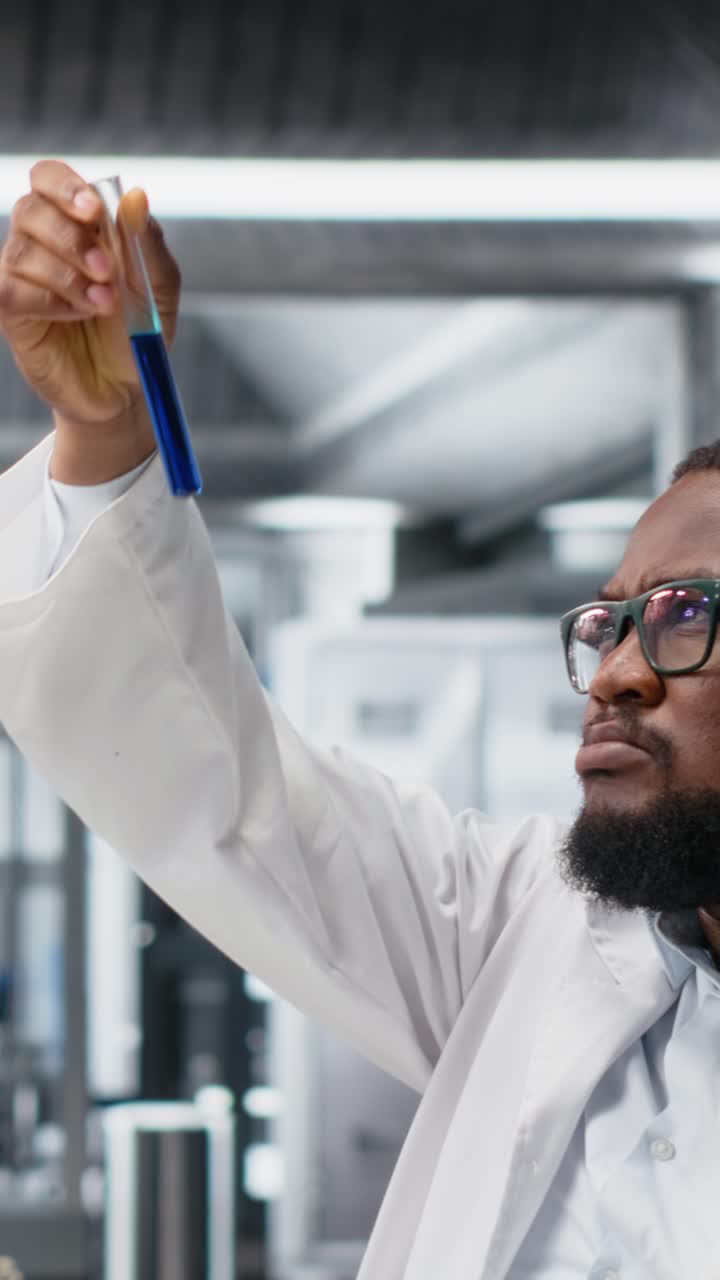 Vertical video Chemical engineer in lab inspecting chemical compounds using PC software