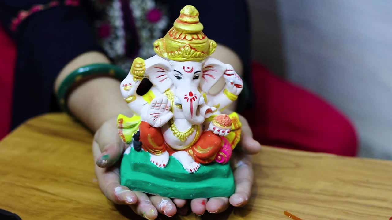 devoto che tiene in mano l'idolo del santo dio indù ganesha da un angolo piatto