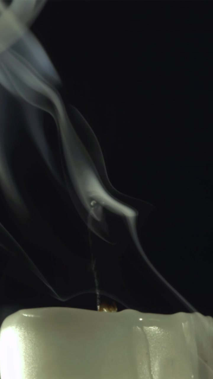 White Smoke Rising from an Extinguished Candle Wick on Black Background