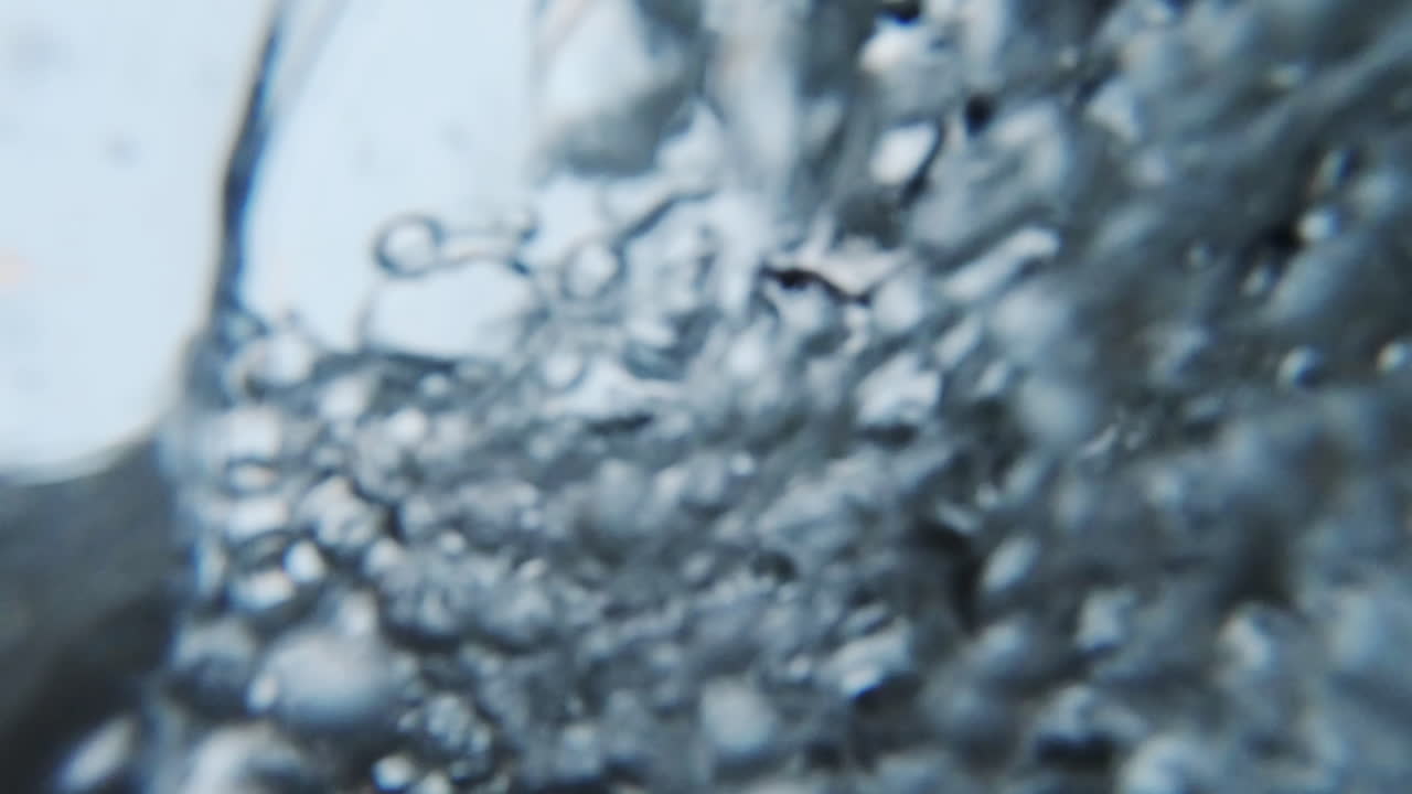 Water bubbles Close up. Slow motion video of air released from the water. Air bubbles floating from sea bottom to the water surface.