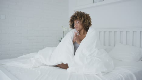 Happy-woman-on-bed-with-blanket