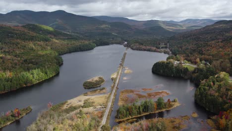 Railroad-Tracks-over-Lake-in-Breathtaking-New-England-Fall-Scenery,-Aerial