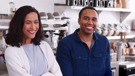 Mixed-race-couple-behind-the-counter-at-their-coffee-shop