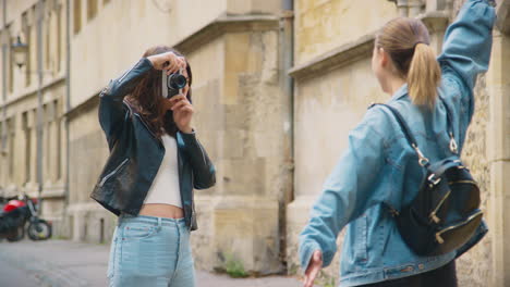 hetzelfde geslacht vrouwelijk koppel neemt foto's van elkaar op retro digitale camera rond oxford uk samen