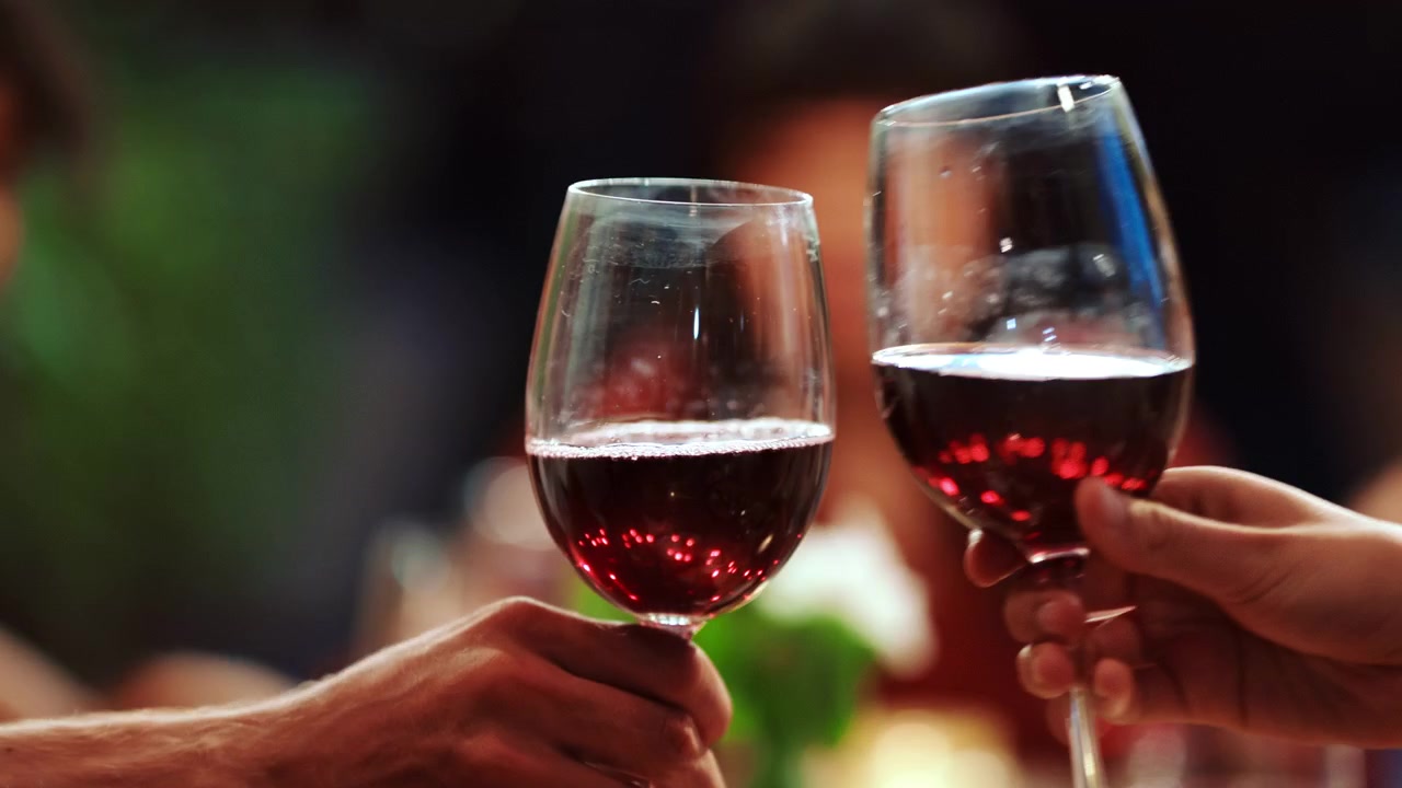 Friends Toasting with Red Wine at a Dinner Party