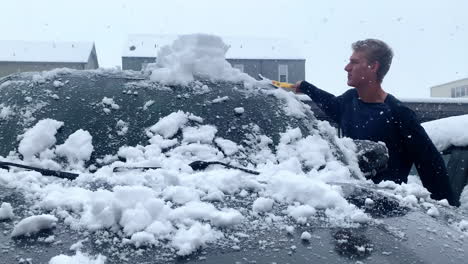 Mann-Räumt-Schnee-Vom-Auto-Während-Eines-Schneesturms-In-Montana,-4k,-Zeitlupe