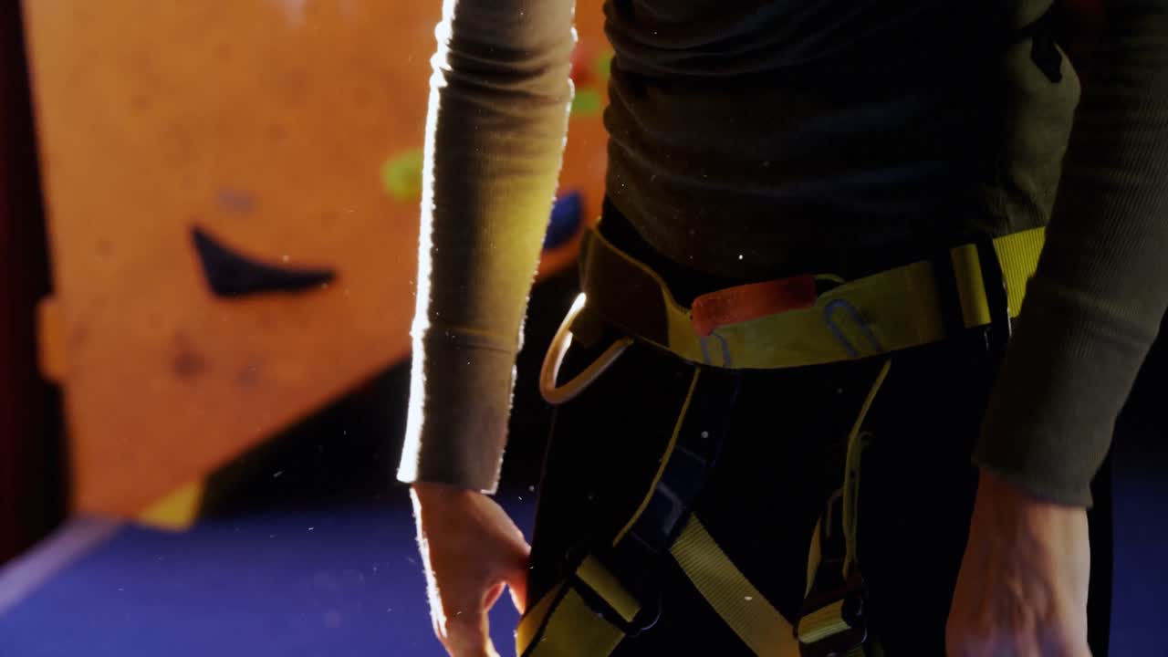 Kvinde tager sin klatresele på i bouldercenter 4k
